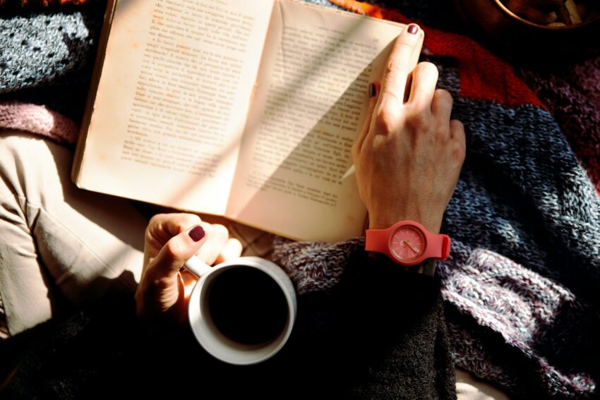 Person drinking coffee and reading book. Credit: Vincenzo Malagoli, Pexels